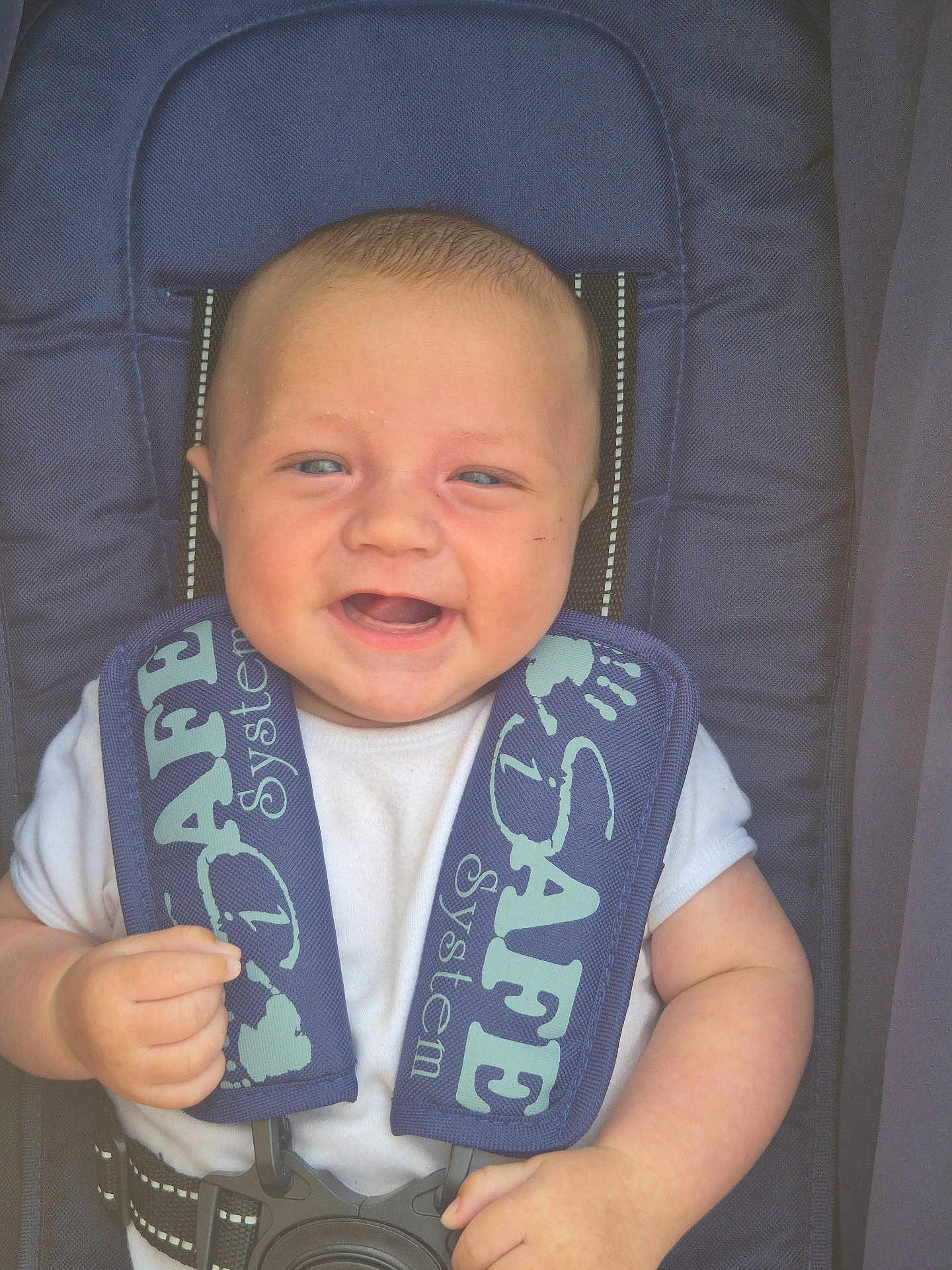 Waylan is registered to the contest to win money with this photo: baby, child, smiling, car_seat, safety_straps, white_shirt, infant, happy, closeup, blue, seat, hands, cute, portrait, person, baby_face, infant_clothing, safety, child_seat, baby_hands