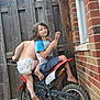 Antonio joined the competition — help win amazing prizes! child, children, dirt_bike, motorbike, diaper, popsicle, smile, outdoor, fence, brick_wall, bucket, barefoot, play, summer, fun, curly_hair, shorts, tshirt, backyard, young