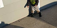 Raffael joined the competition — help win amazing prizes! child, boy, shadow, wall, sidewalk, concrete, casual_clothing, sweatshirt, pants, boots, outdoor, sunlight, afternoon, playful, leaning, standing, young, hair, expression, background