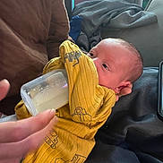 Ronin joined the competition — help win amazing prizes! baby, blanket, bottle, care, clothing, comfort, cushion, cute, face, feeding, hand, indoors, infant, milk, newborn, person, resting, soft_fabric, yellow_onesie, young_child