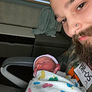 Ronin joined the competition — help win amazing prizes! baby, adult, beard, blanket, colorful, duck_pattern, face, hospital, indoor, newborn, nose_piercing, person, portrait, swaddled, together, warmth, young, caring, family, closeup