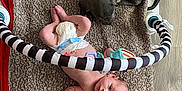 Ronin joined the competition — help win amazing prizes! baby, baby_gym, blanket, curious_baby, cute, diaper, dog, floor, indoor, infant, pacifier, pet, play_area, puppy, resting, sleeping_dog, soft_texture, striped_bar, toy, wood_floor