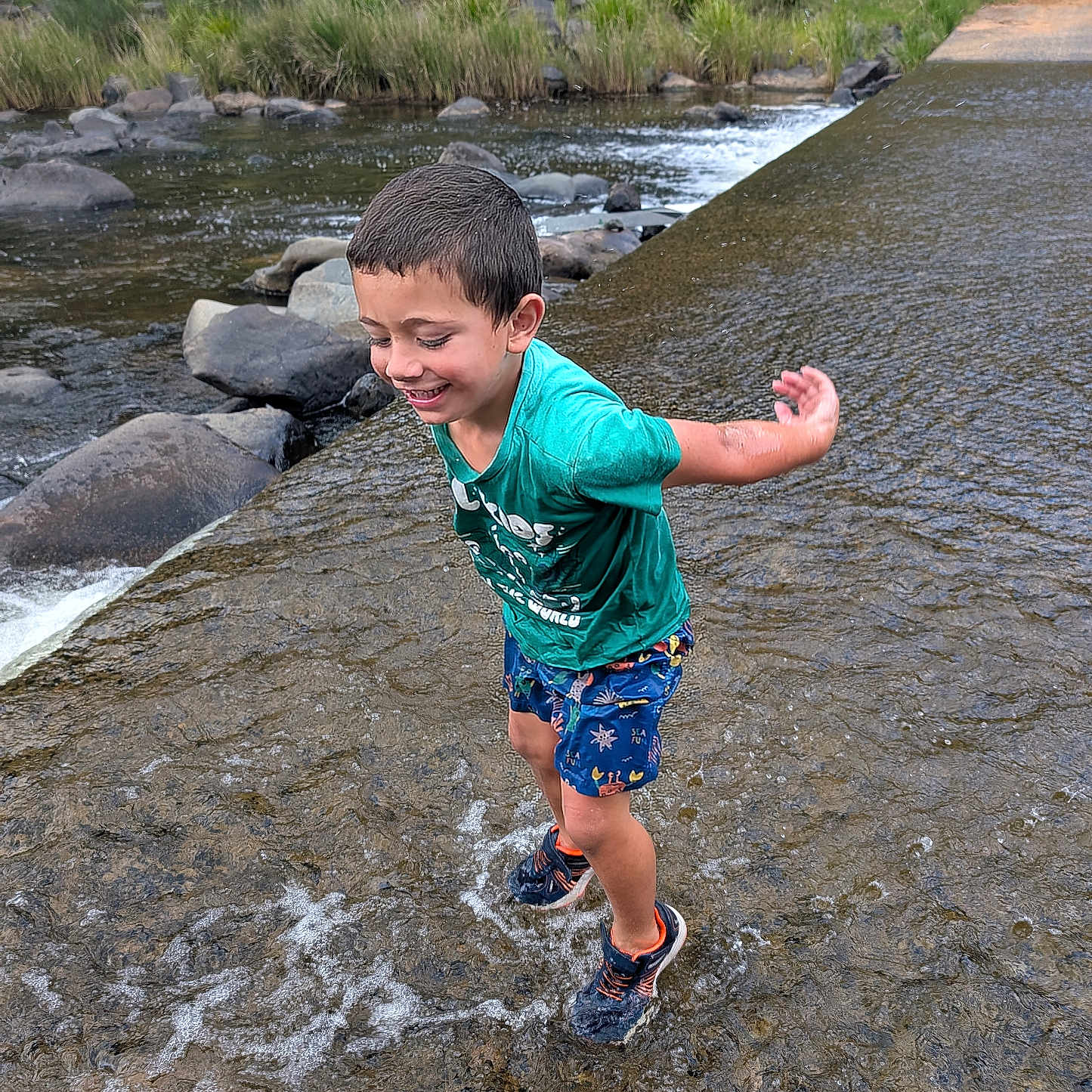 Jymarlee is registered to the contest to win money with this photo: child, boy, water, river, rocks, splashing, happy, outdoor, nature, greenery, shorts, tshirt, shoes, play, smile, water_flow, summer, fun, active, recreation