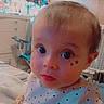 baby, child, infant, portrait, close_up, wide_eyed, polka_dot_clothing, star_stickers, indoors, bedroom, dresser, baby_gear, furniture, soft_lighting, colorful, looking_at_camera, face, head, cute, photograph