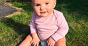 Leilani is registered to the contest to win money with this photo: baby, casual, child, curious_expression, daylight, face, fence, grass, infant, lawn, lifestyle, nature, outdoor, person, pink_clothing, sitting, sock, sunlight, wooden_fence, yard