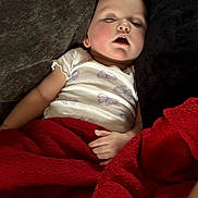 Leilani joined the competition — help win amazing prizes! baby, sleeping, blanket, red_blanket, couch, white_shirt, butterflies, child, resting, indoor, relaxation, cozy, peaceful, portrait, infant, hand, face, soft_lighting, comfort, home