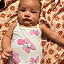 Eliana is registered to the contest to win money with this photo: baby, infant, onesie, pink, heart, bow, blanket, floral_pattern, lying_down, child, cute, skin, expression, soft_lighting, indoors, chubby, young_child, portrait, person, comfortable