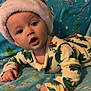 baby, infant, santa_hat, pajamas, dinosaur_pattern, blanket, candy_cane, christmas_tree, holiday_theme, blue_blanket, cute, child, indoor, portrait, face, hands, expression, cozy, soft, lying_down