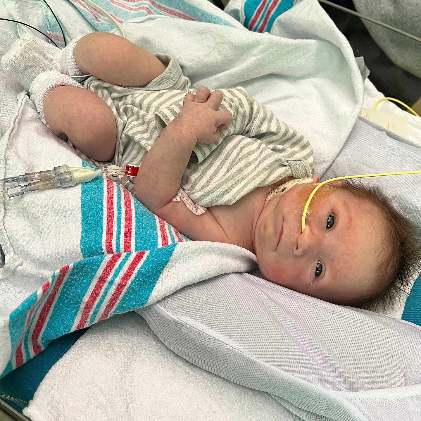 Hunter is registered to the contest to win money with this photo: architecture, baby, bed, blanket, bodypart, building, clothing, crib, face, finger, furniture, glove, head, hospital, indoors, infantbed, newborn, person, photography, portrait