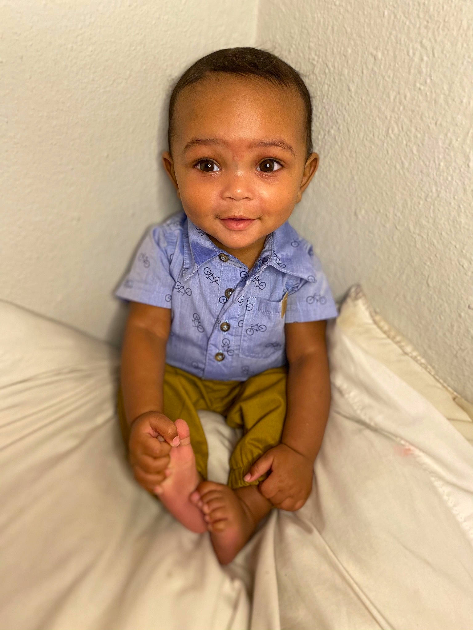 Dakari is registered to the contest to win money with this photo: baby_toddler_clothing, bed, bed_sheet, bedding, cheek, child, comfort, ear, elbow, eye, finger, forehead, hand, iris, linens, nose, person, skin, sock, textile