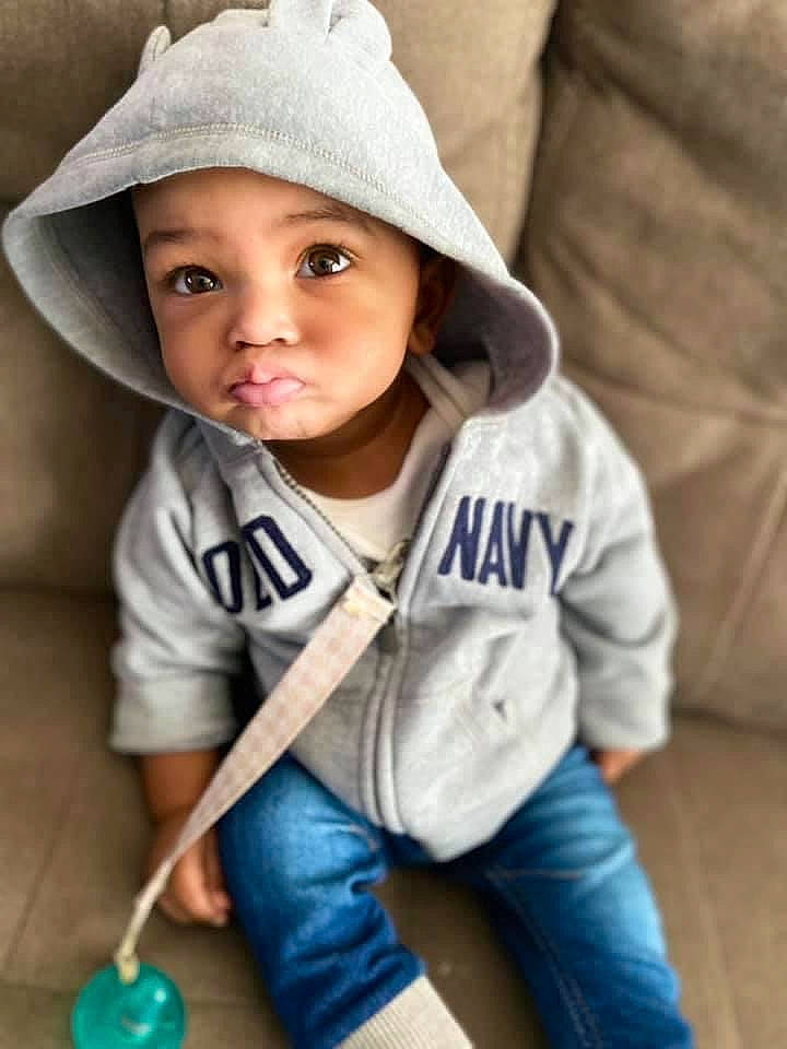 Dakari joined the competition — help win amazing prizes! baby, baby_toddler_clothing, bonnet, cheek, child, child_model, comfort, costume_accessory, costume_hat, couch, denim, headwear, human, jeans, living_room, mouth, nose, person, play, sun_hat