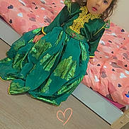 Alice a rejoint le concours — aidez-le/la à gagner de superbes lots ! child, girl, dress, green_dress, bed, pink_bedspread, heart_pattern, floor, wooden_floor, curly_hair, indoors, portrait, expression, sitting, person, decor, home, cute, young, face