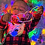 Odin is registered to the contest to win money with this photo: baby, child, christmas_lights, red_clothing, checkered_pattern, onesie, holiday_theme, gingerbread_men, colorful_lights, festive, cute, indoors, wall_decor, smiling_bear, toddler, face, hands, playing, celebration, warm_lighting