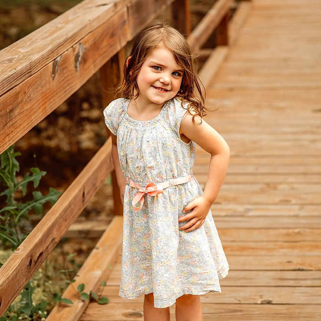 Willow joined the competition — help win amazing prizes! child, cute, dress, fashion, girl, greenery, hand_on_hip, happy, nature, outdoor, playful, portrait, posing, sandals, smiling, standing, summer, sunlight, wooden_bridge, young