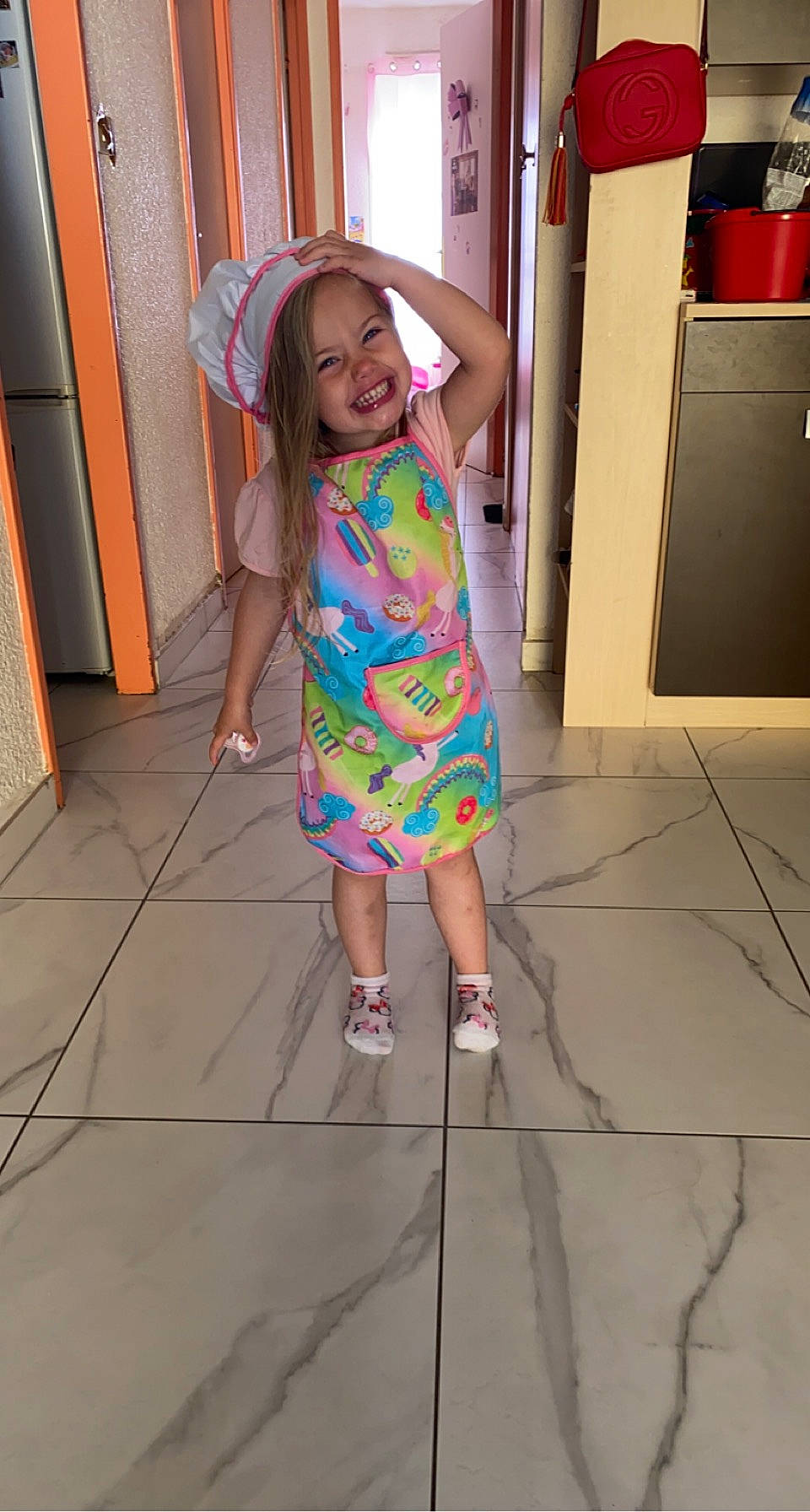Leyana participe au concours pour gagner de l'argent avec cette photo : door, dress, facial_expression, floor, flooring, footwear, fun, happy, hat, head, joy, leg, magenta, person, pink, purple, sandal, smile, standing, television