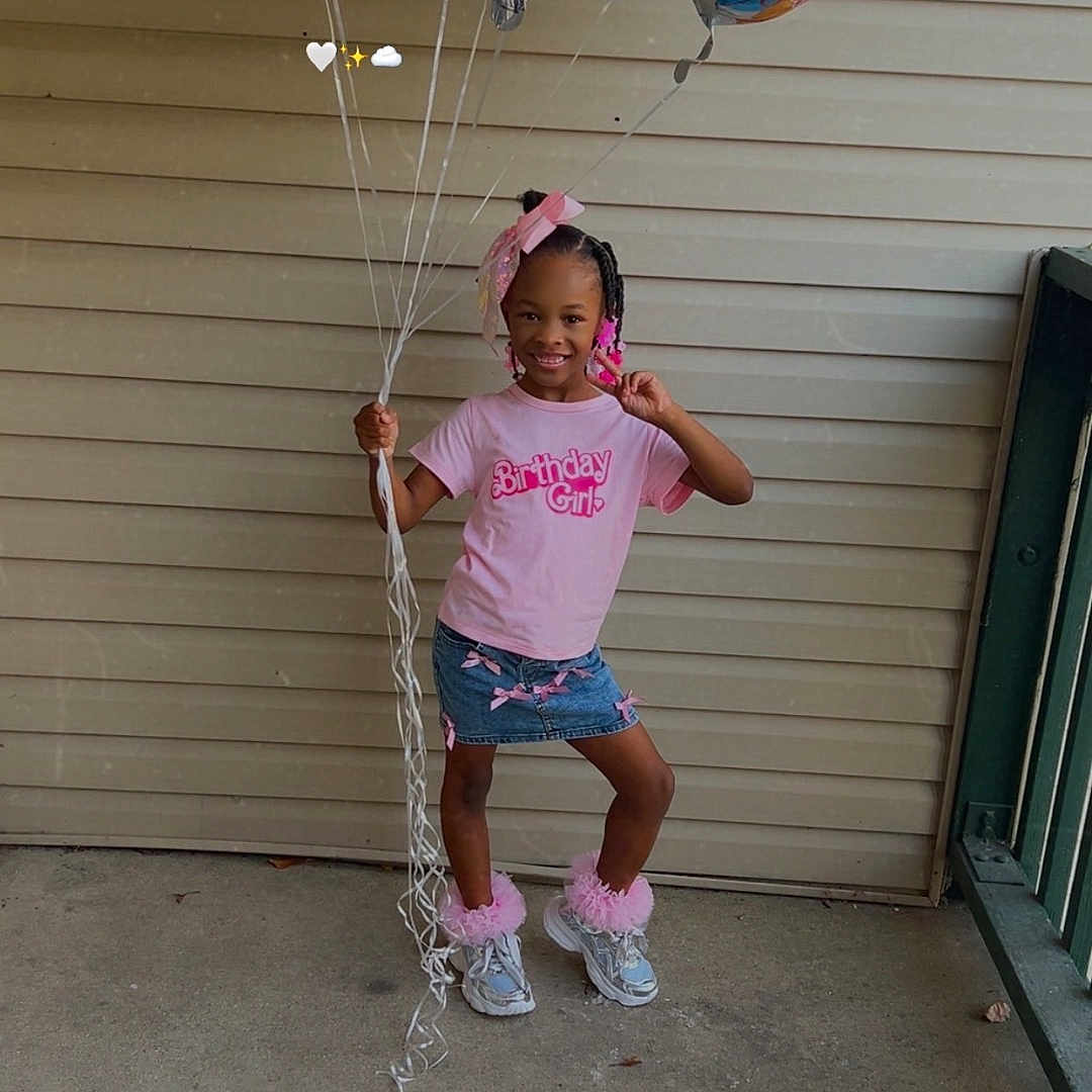 Tommie Jones joined the competition — help win amazing prizes! balloons, birthday_girl, bow, celebration, child, concrete_floor, denim_skirt, fashion, girl, hair_beads, helium_balloons, outdoor, party, pink, porch, pose, railing, siding, smile, sneakers
