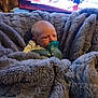 Theo is registered to the contest to win money with this photo: baby, pacifier, blanket, gray, infant, face, indoor, soft_texture, cozy, newborn, person, wrapped, comfort, couch, television, furniture, child, young, relaxing, home