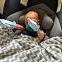 baby, newborn, car_seat, blanket, pacifier, mittens, sleeping, infant, child, seatbelt, fabric, pattern, comfort, indoor, rest, cute, soft, head, person, nap
