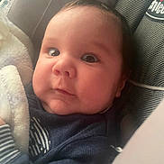 Mike is registered to the contest to win money with this photo: baby, blanket, car_seat, child, closeup, clothing, cozy, cute, expression, eyes, face, head, indoor, infant, newborn, person, portrait, soft_light, warm, young