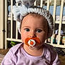 baby, infant, pacifier, headband, blue_eyes, purple_shirt, crib, toy, indoor, child, cute, sitting, soft_toys, blanket, person, portrait, closeup, love_message, toddler, home