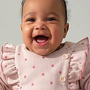 Mia a rejoint le concours — aidez-le/la à gagner de superbes lots ! baby, smiling, happy, curly_hair, pink_outfit, polka_dots, ruffles, buttons, infant, portrait, child, cute, joyful, indoor, closeup, person, clothing, face, expression, young