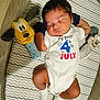 Armando is registered to the contest to win money with this photo: baby, newborn, sleeping, infant, onesie, plush_toy, mattress, pattern, socks, cute, peaceful, indoor, child, resting, soft_toys, celebration, holiday_clothing, face, hands, legs