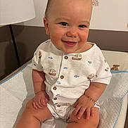 Giulio a rejoint le concours — aidez-le/la à gagner de superbes lots ! baby, child, smiling, onesie, bracelet, sitting, indoor, changing_pad, cute, happy, infant, clothing, face, hand, leg, nursery, lamp, pattern, furniture, skin