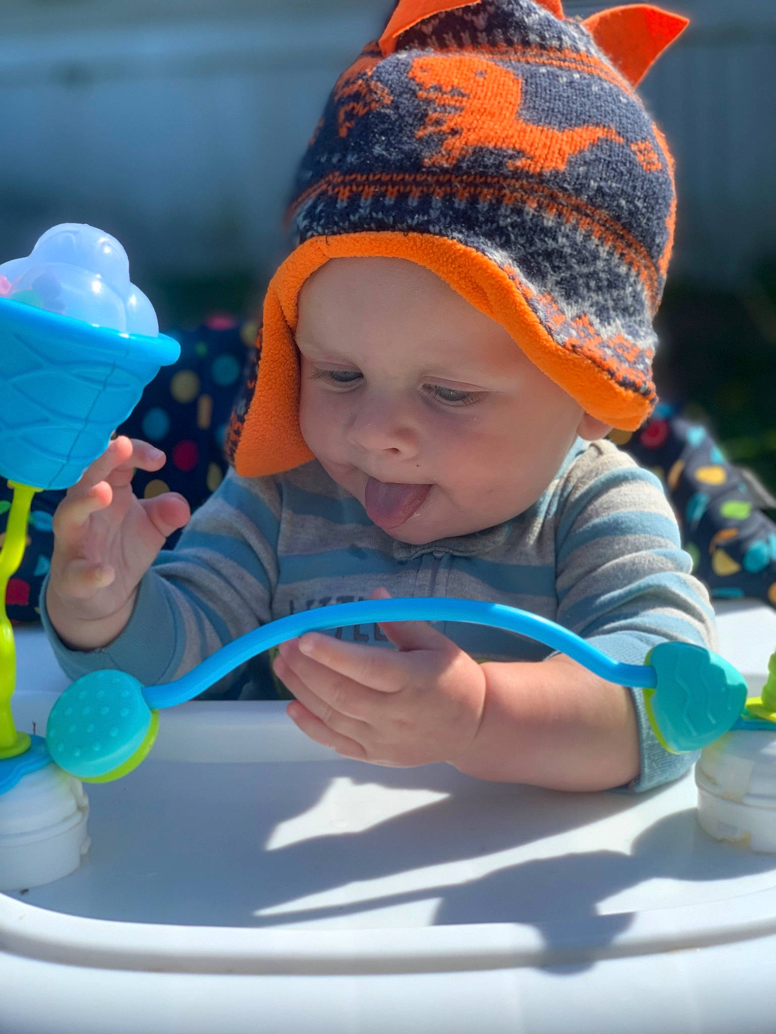 Gavin is registered to the contest to win money with this photo: baby, baby_products, baby_toddler_clothing, blue, cap, child, electric_blue, facial_expression, fashion_accessory, fun, grass, happy, headgear, headwear, human_body, leisure, person, recreation, sitting, skin