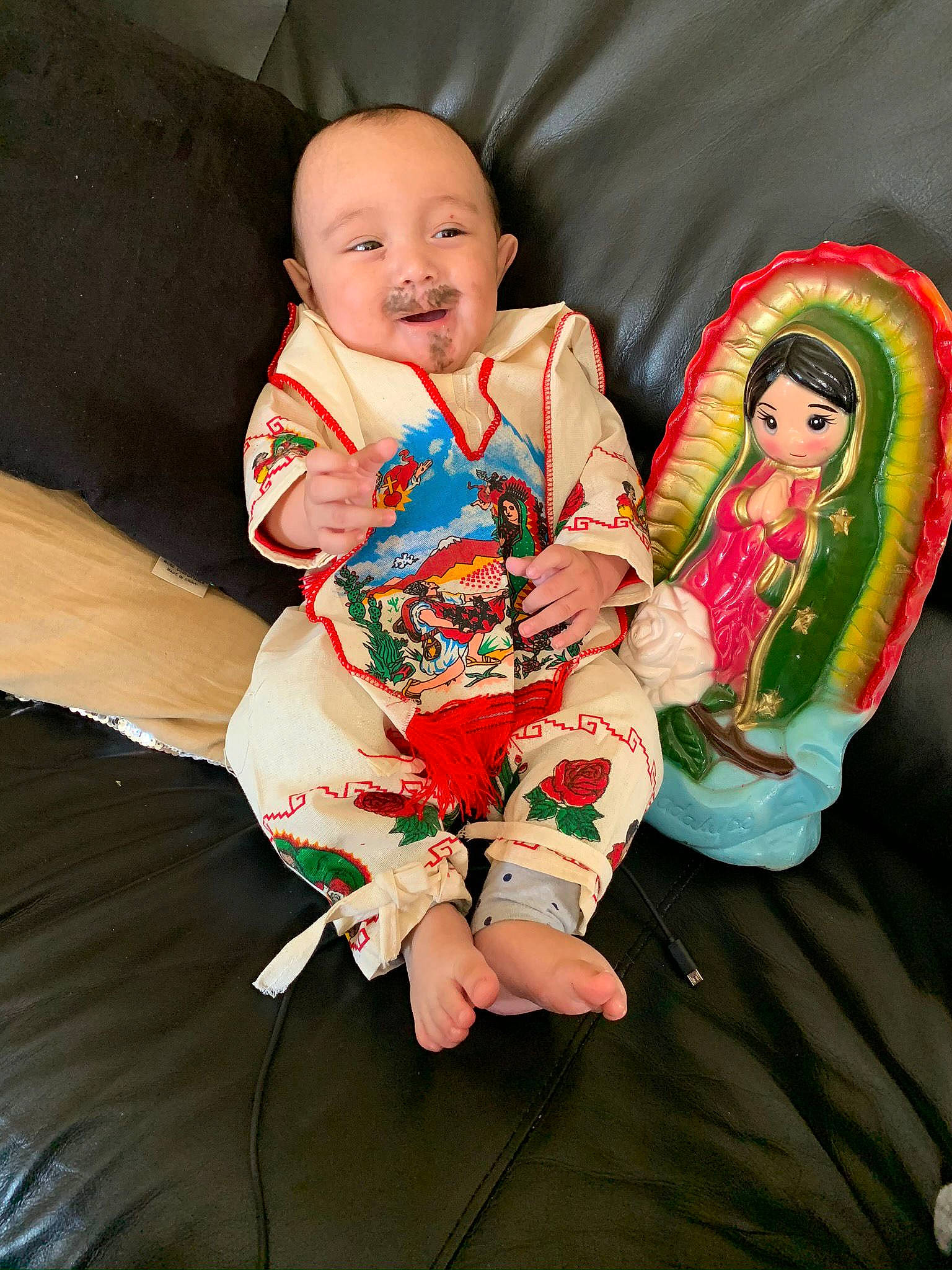 Jesus is registered to the contest to win money with this photo: baby, baby_products, baby_toddler_clothing, carmine, cheek, child, christmas, comfort, event, fictional_character, foot, fun, happy, holiday, lap, person, sitting, sleeve, smile, sock