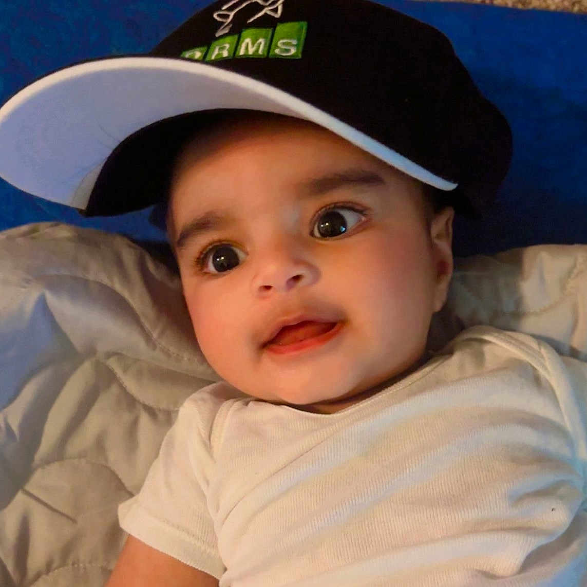 Orhan joined the competition — help win amazing prizes! baby, blanket, cap, child, closeup, clothing, cute, expression, eyes, face, hat, headwear, indoors, infant, laying_down, person, portrait, skin, smile, young