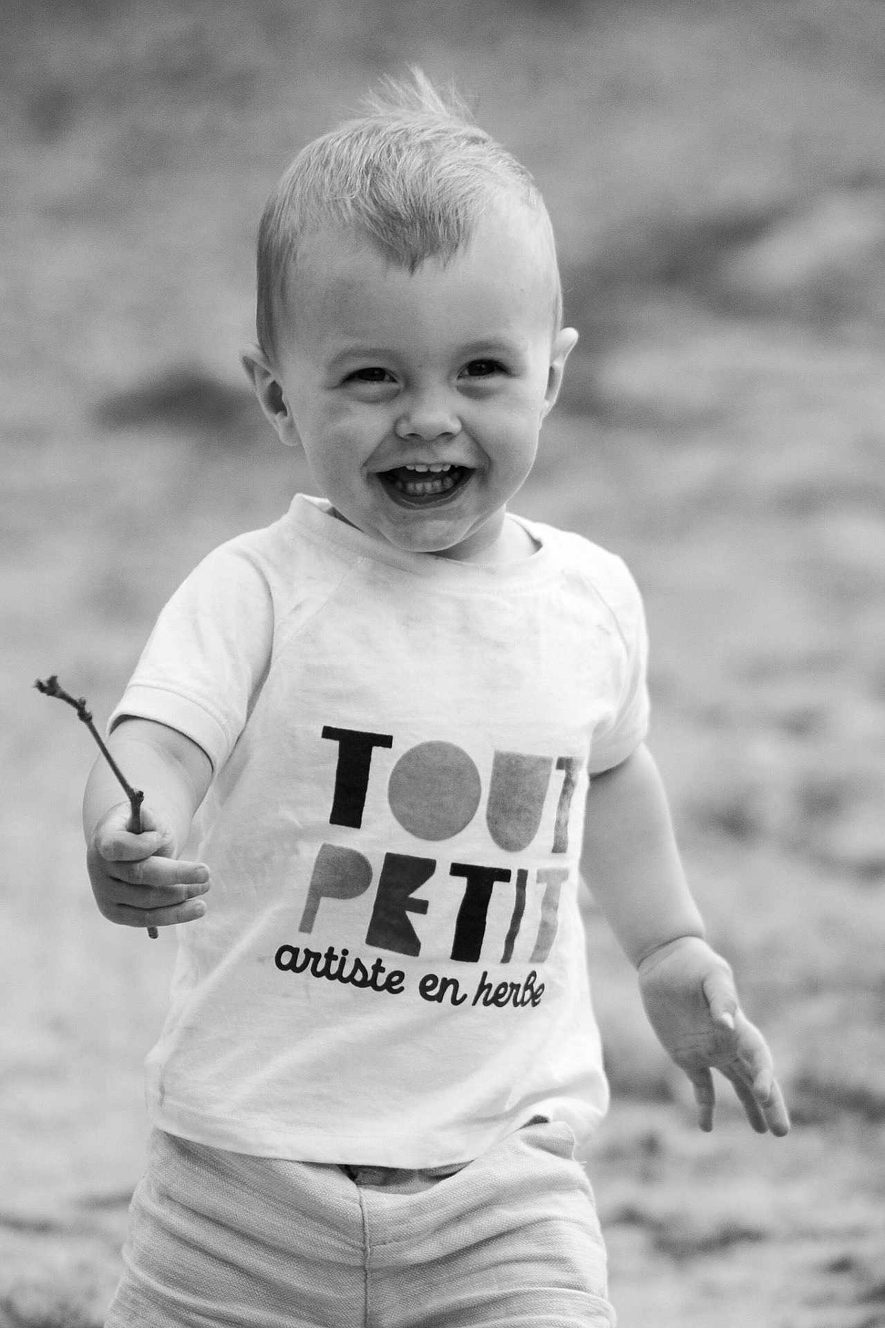 Lewis a rejoint le concours — aidez-le/la à gagner de superbes lots ! toddler, child, smiling, black_and_white, shirt, shorts, stick, outdoor, portrait, happy, walking, hair, face, person, young_child, expression, playful, cute, monochrome, nature