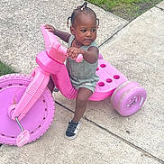 Egypt joined the competition — help win amazing prizes! toddler, child, tricycle, pink, outdoor, sidewalk, grass, toy, play, braids, beads, sneakers, concrete, person, vehicle, summer, casual_clothing, cute, young, fun