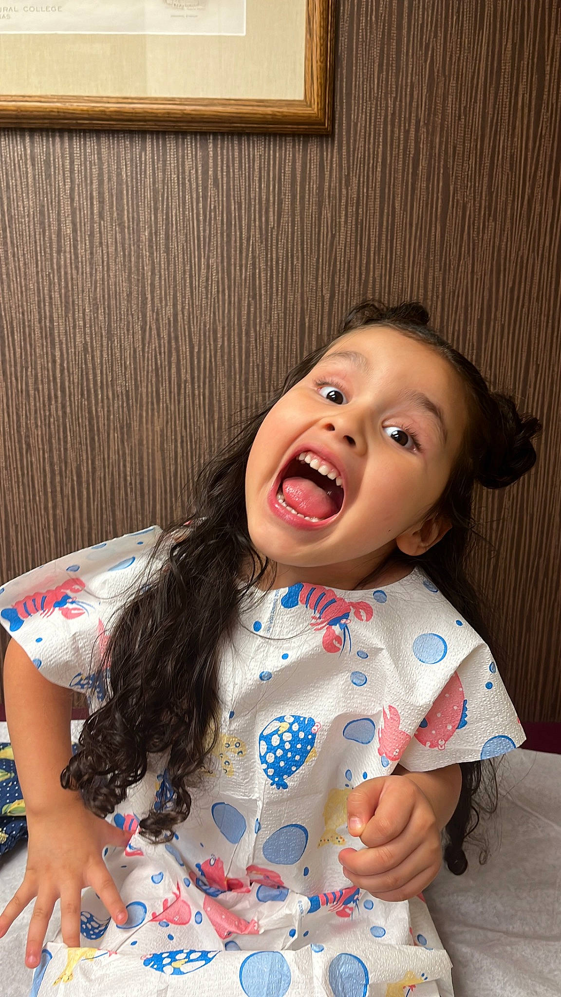 Gabriella is registered to the contest to win money with this photo: baby_toddler_clothing, cheek, child, chin, eyelash, fun, gesture, happy, laugh, lip, mouth, nose, person, picture_frame, sitting, skin, sleeve, smile, t_shirt, toddler