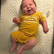 Amelia is registered to the contest to win money with this photo: baby, infant, smiling, yellow_clothing, onesie, pacifier, blanket, texture, cute, happy, lying_down, chubby, skin, human, child, indoors, soft_lighting, newborn, face, expression