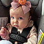 Amelia joined the competition — help win amazing prizes! baby, car_seat, bow, pumpkin, infant, child, straps, clothing, soft_toy, cute, portrait, indoors, seatbelt, face, person, expression, headwear, closeup, safety, pink