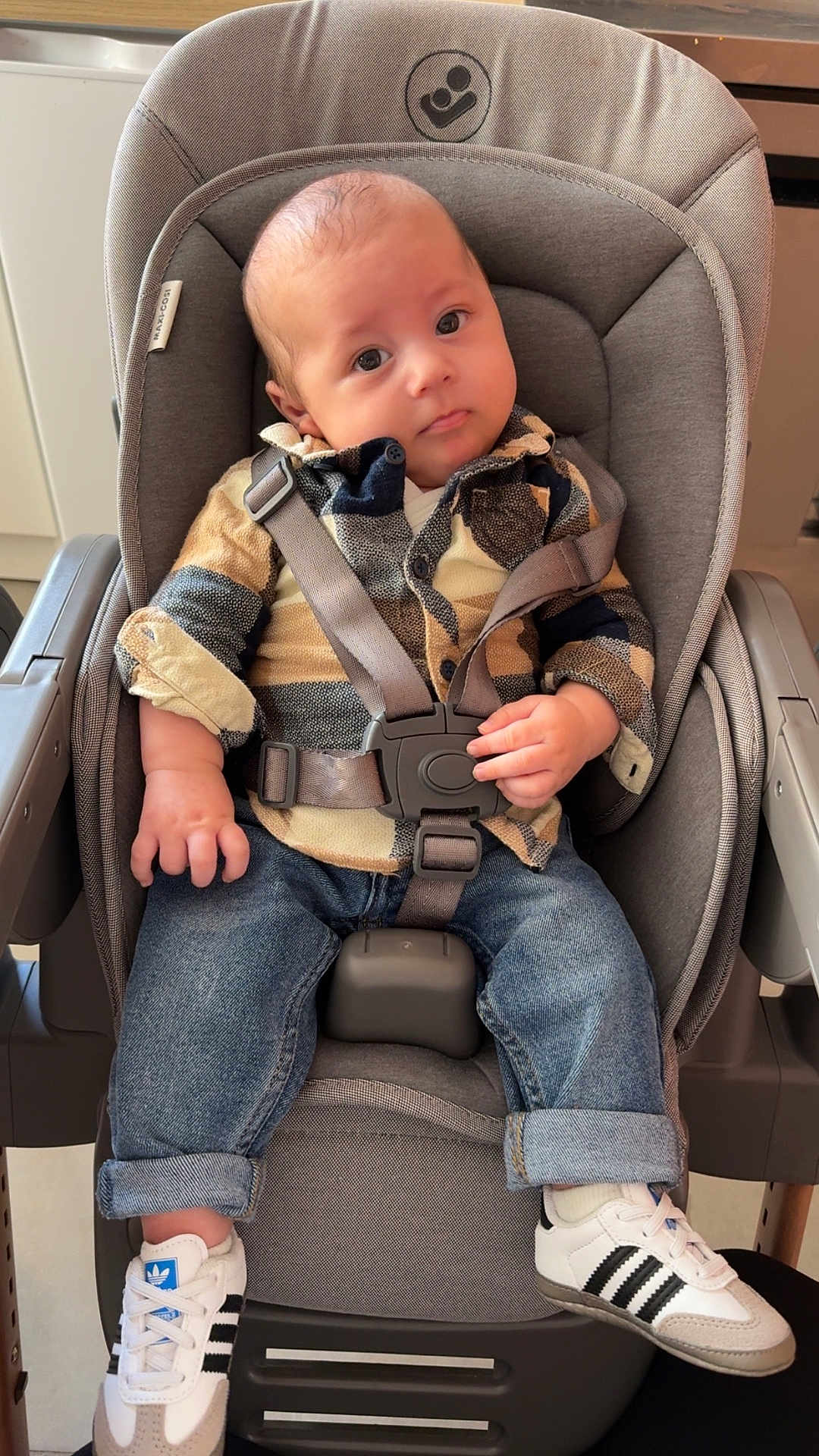 Elio a rejoint le concours — aidez-le/la à gagner de superbes lots ! baby, car_seat, child, indoor, denim_jeans, shoes, sneakers, straps, seated, curious, face, person, clothing, footwear, infant, casual_wear, expression, head, comfortable, modern