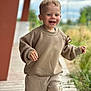 Soan participe au concours pour gagner de l'argent avec cette photo : toddler, child, smiling, outdoor, beige_clothing, sweatshirt, pants, happy, walking, blond_hair, blue_eyes, nature, pathway, greenery, daylight, casual, cute, portrait, person, blurred_background
