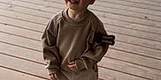 Soan participe au concours pour gagner de l'argent avec cette photo : toddler, child, smiling, sweatshirt, pants, shoes, wooden_deck, outdoor, happy, person, casual_clothing, cute, standing, young_child, daylight, playful, patch, fabric, feet, portrait