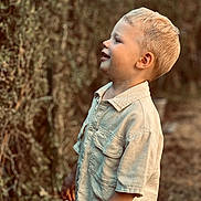 Soan participe au concours pour gagner de l'argent avec cette photo : child, blonde_hair, smiling, profile_view, outdoor, greenery, nature, shirt, short_sleeves, young_boy, innocent, happy, portrait, casual_clothing, daylight, standing, cute, person, background_blur, face