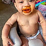 baby, diaper, messy_face, baby_food, high_chair, indoor, smiling, child, seat, toy, carpet, cute, infant, person, happy, face, arm, hand, mouth, orange_food