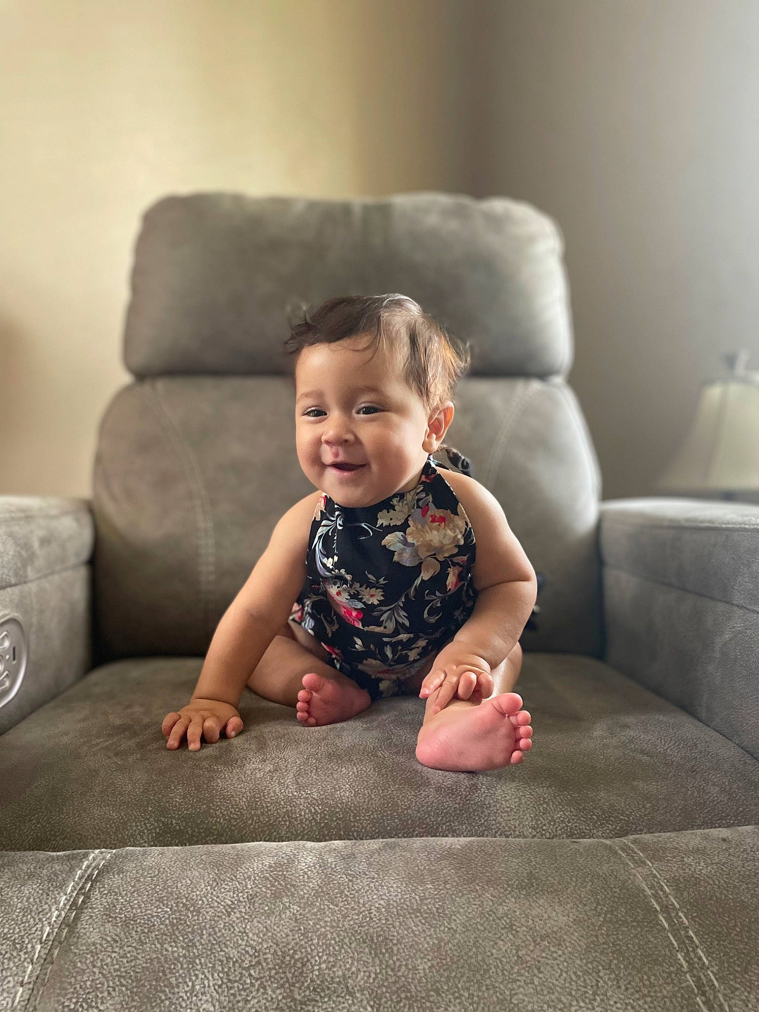 Ailani is registered to the contest to win money with this photo: baby, baby_toddler_clothing, child, comfort, couch, facial_expression, flash_photography, flooring, grey, hair, hairstyle, happy, head, human, joy, people, person, skin, sleeve, smile