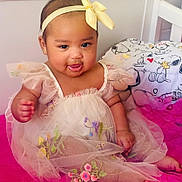 Florencia joined the competition — help win amazing prizes! baby, child, dress, headband, yellow_bow, smile, drool, sitting, pink_surface, bedroom, bedding, snoopy, cartoon, cute, portrait, indoors, infant, adorable, happy, tulle