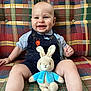 Johnny joined the competition — help win amazing prizes! baby, smiling, child, plush_toy, bunny, stuffed_animal, denim_overalls, couch, plaid_pattern, happy, infant, blue_jacket, sitting, indoor, cute, person, toy, face, legs, clothing