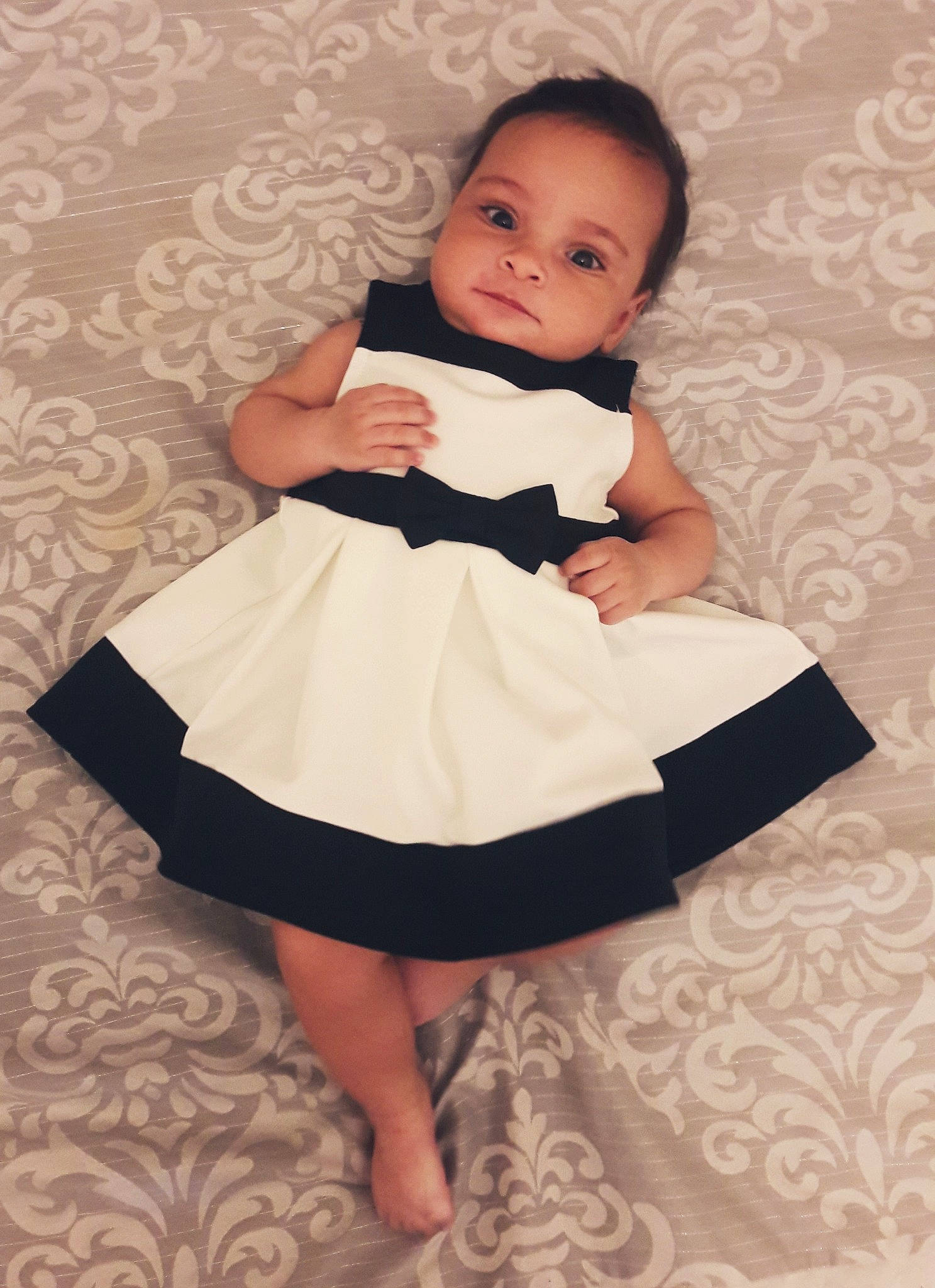 Angelique is registered to the contest to win money with this photo: baby, baby_products, baby_toddler_clothing, black_and_white, child, child_model, clothing, costume, design, dress, footwear, leg, pattern, person, product, sitting, skin, sleeve, toddler, white