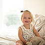 Piper joined the competition — help win amazing prizes! toddler, child, smiling, bed, stuffed_animal, toy, pillow, window, natural_light, indoor, cute, happy, blonde_hair, casual_clothing, portrait, home, cozy, sitting, soft, relaxed