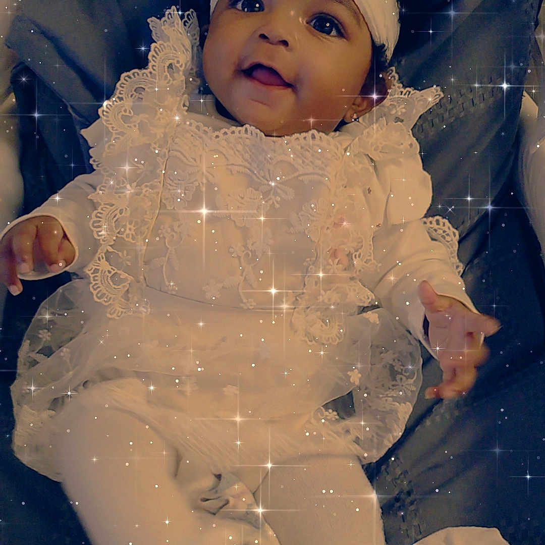 Ba'Cardi is registered to the contest to win money with this photo: adorable, baby, bow, child, cushion, cute, dark_background, feet, hands, happy, headband, infant, lace, lying_down, portrait, smiling, soft_lighting, sparkles, stars, white_clothing
