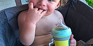 Johnathan is registered to the contest to win money with this photo: toddler, child, curly_hair, sippy_cup, fingers_in_mouth, stroller, outdoor, grass, toy, denim_shorts, baby, cute, smiling, seatbelt, playtime, innocent, happy, summer, casual, portrait