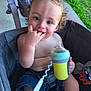 toddler, child, curly_hair, sippy_cup, fingers_in_mouth, stroller, outdoor, grass, toy, denim_shorts, baby, cute, smiling, seatbelt, playtime, innocent, happy, summer, casual, portrait