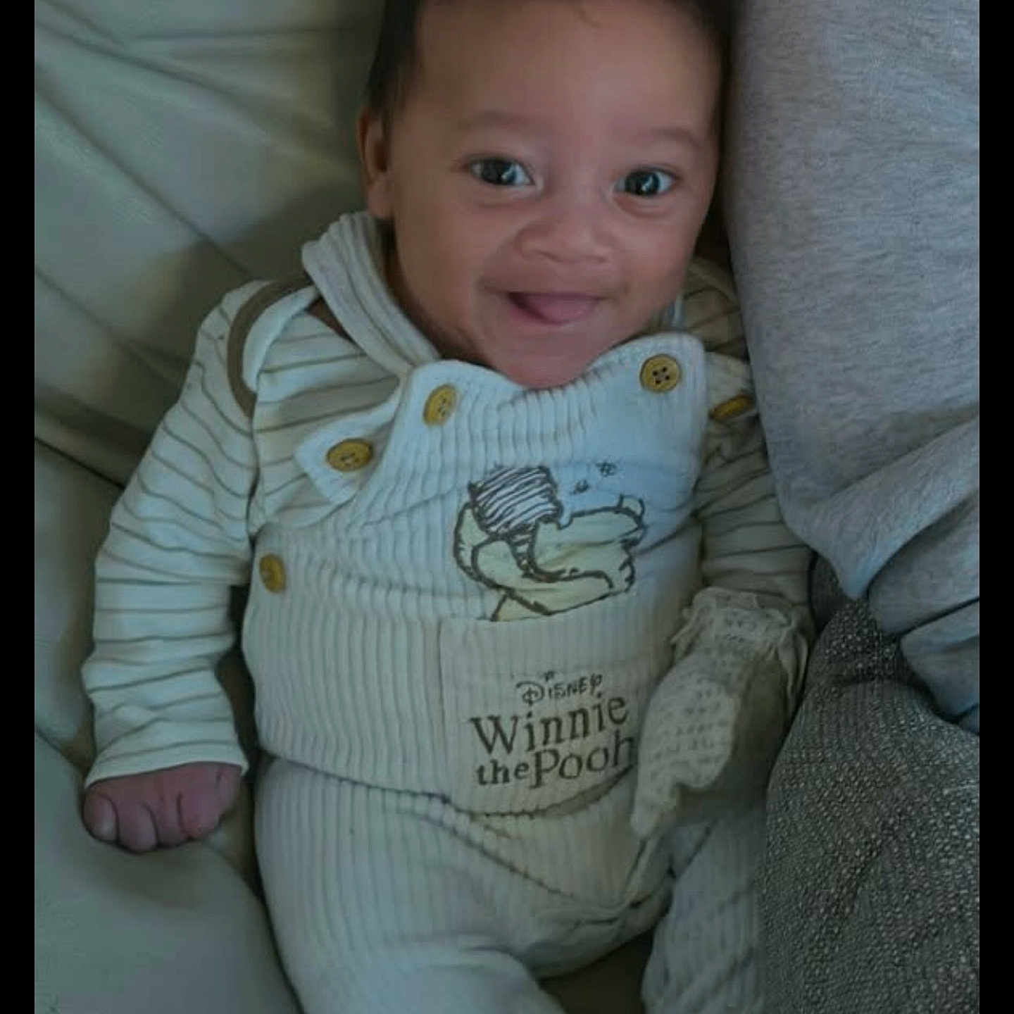 Noah Paul Augustin a rejoint le concours — aidez-le/la à gagner de superbes lots ! baby, button, child, clothing, couch, cozy, cute, face, hand, happy, indoor, infant, onesie, person, portrait, sitting, smile, soft, striped, winnie_the_pooh