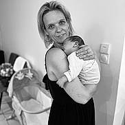 Elio participe au concours pour gagner de l'argent avec cette photo : arm, baby, bassinet, black_and_white, clothing, earrings, face, floor, furniture, holding, home, indoor, love, newborn, person, portrait, ring, sleeping, tenderness, woman